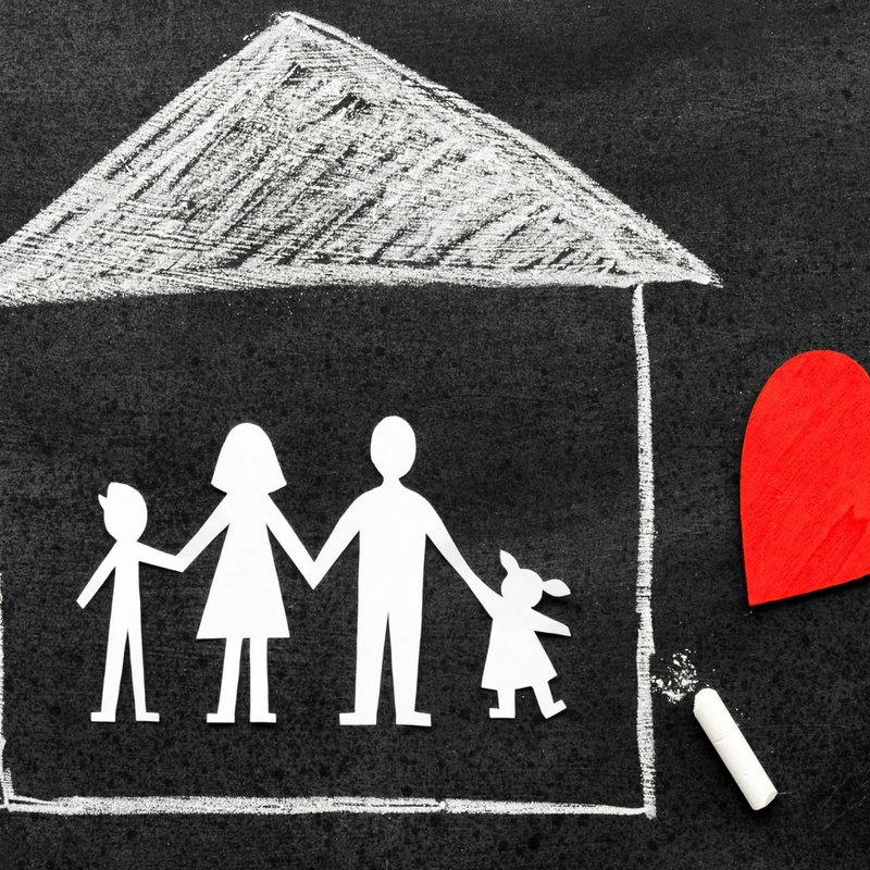 mit Kreide gezeichnetes Haus und Familie, rotes Herz